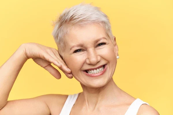 mulher-meia-idade-com-cabelo grisalho-com-fundo-amarelo